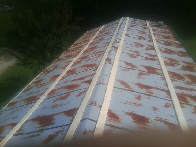 Rusted metal roof panels with new wood purlins before replacement — Storm Damage Roof Repair in Plover by Roofing Brothers