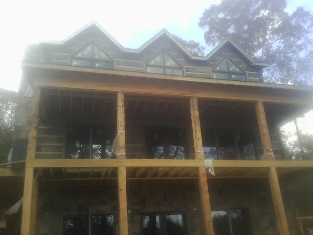 Dormers and porch framing on a large log home under construction — Roof Coating work by our crew in Plover